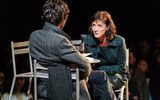 Production photo from Julius Caesar. Taken from behind Ben Whishaw we see him and the front of Michelle Fairley sat opposite each other. Michelle is leaning in as if to talk in secret to Ben.