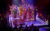 The cast all dance with their arms in the air as Cedric Neal sings while standing on top of the desk in the Save A Soul Mission