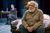 JGB-0087 Simon Russell Beale sits slouched, wearing a beige cardigan, his hands clasped in his lap