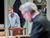 Sthbry-039 Phoebe Nicholls stands talking to Alex Jennings who is out of focus in the foreground. She wears a grey cardigan and long skirt.