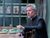Sthbry-088 Alex Jennings sits at a wooden table wearing a black blazer, hiw wedding band can be seen on his finger as he clenches his fist whilst speaking.