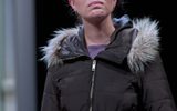 Sarah Twomey stands wearing a puffer jacket, she looks close to tears.