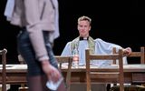 Jack Greenlees sits at a table with his arm leaning on a chair.