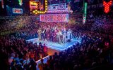 Huge crowds surround a raised platform where the cast of 28 take their bows. Confetti falls on them and neon signs hang above them